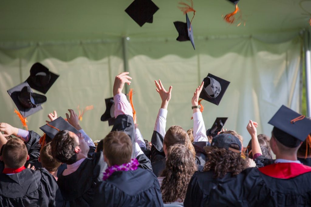 photography-of-people-graduating-1205651 Group of graduates celebrating by tossing caps into the air during a graduation ceremony.